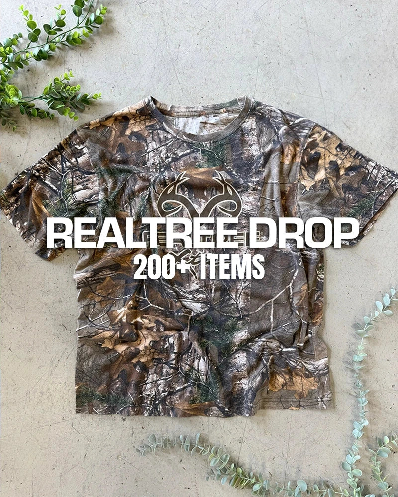 Vintage camo clothing collection featuring RealTree t-shirts, military jackets, and rugged outdoor workwear from the 90s and early 2000s.